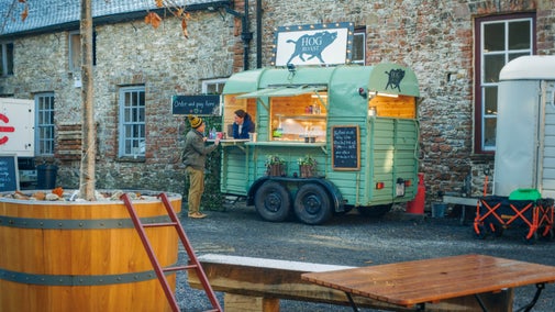 A stallholder taking to a visitor through the trailer hatch at the Christmas Fair in Dinefwr, Carmarthenshire